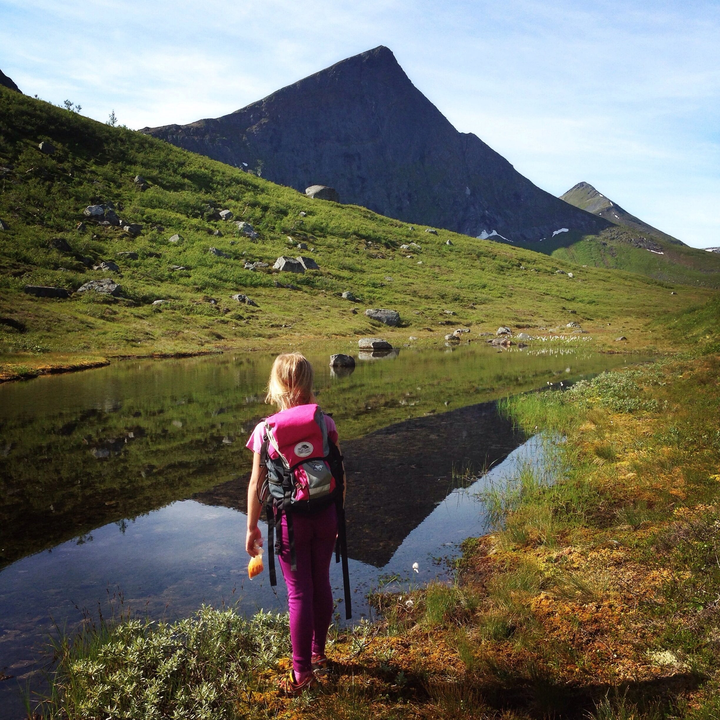 Jente ser utover vann med molter i sekken og h&aring;nda.