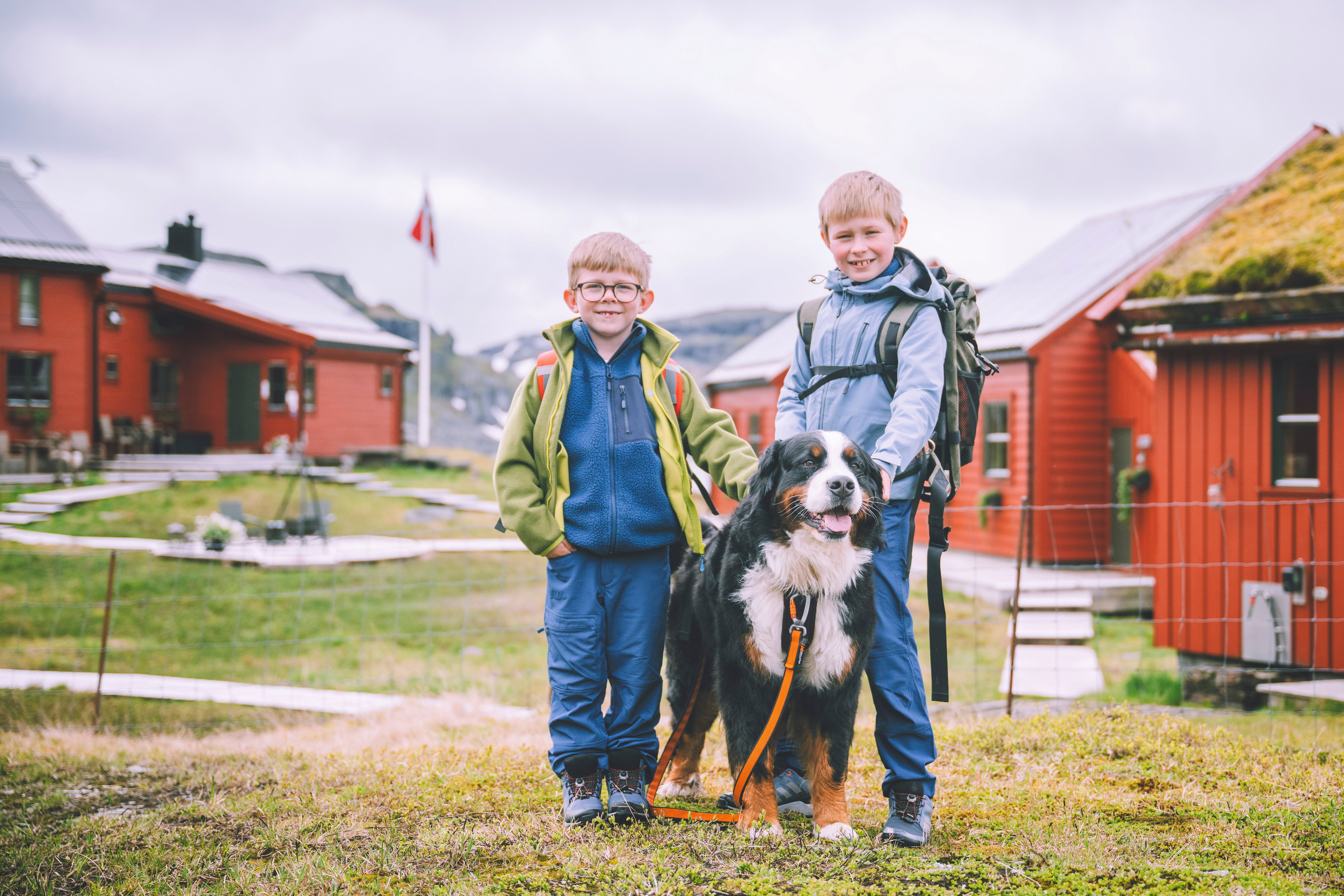 to barn som st&aring;r med en hund mellom seg