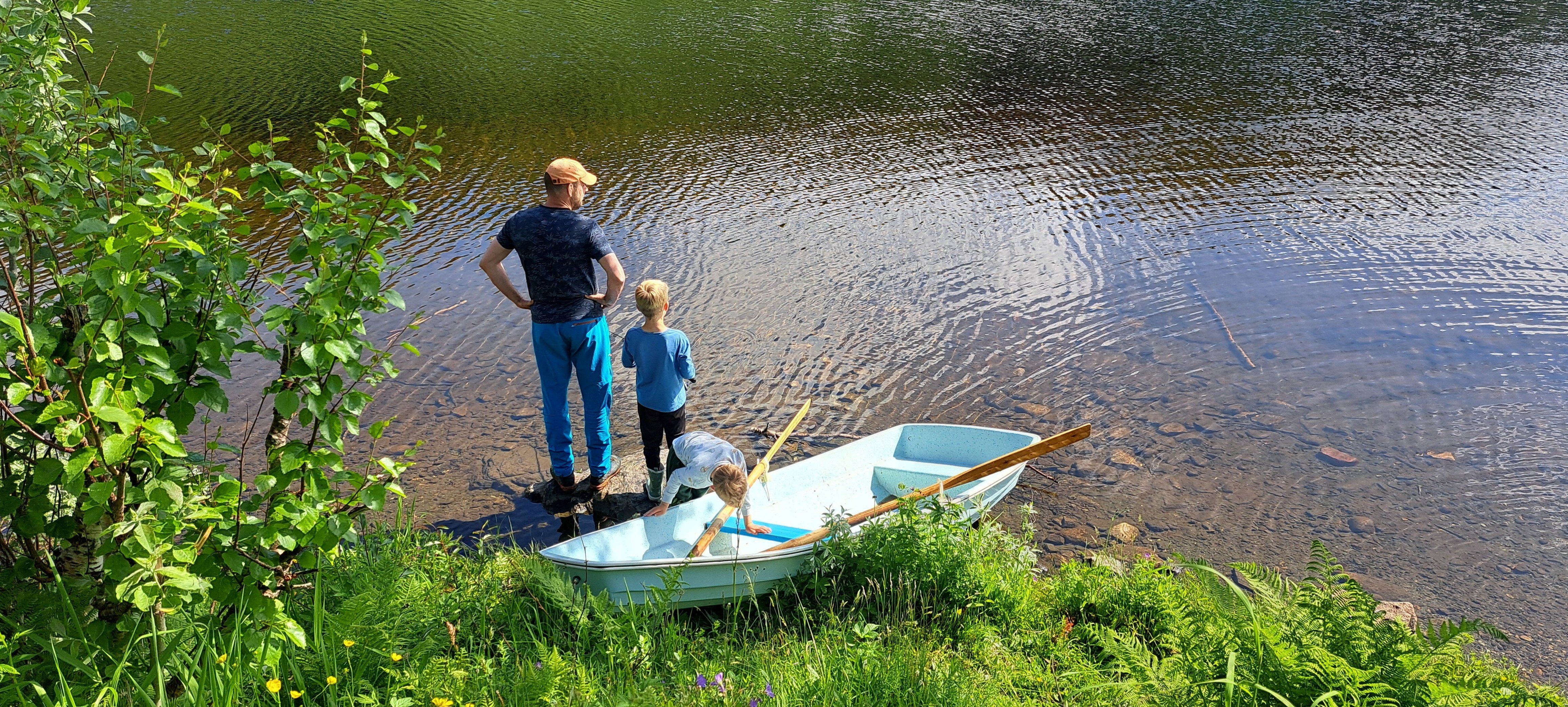 Far og barn st&aring;r ved en liten innsj&oslash; og ser utvoer