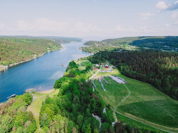 Dronebilde over Breivoll. Vi ser fjorden og gr&oslash;ntomr&aring;der.